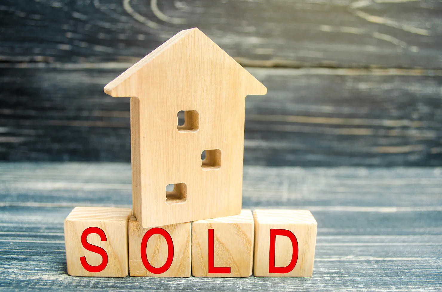 A wooden house on blocks spelling